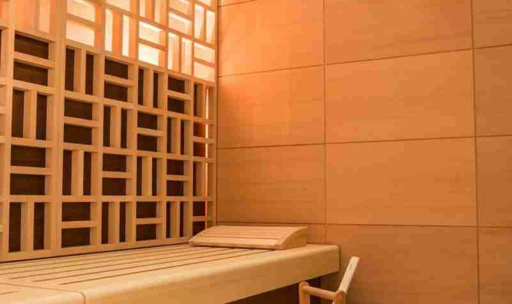Vertical shot of a beautiful sauna room design with wall tiles and wooden bench A vertical shot of a beautiful sauna room design with wall tiles and wooden bench